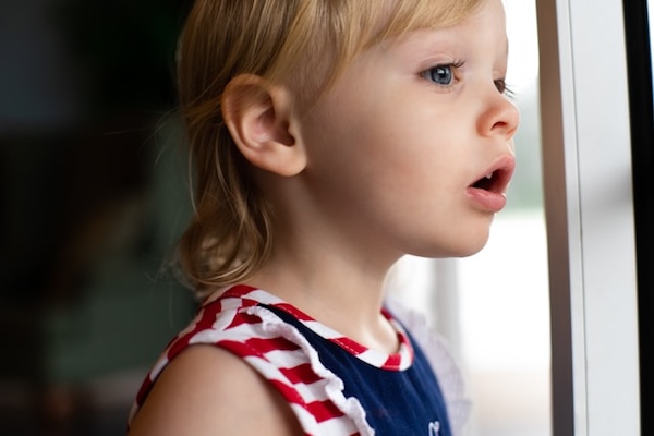 enfant qui regarde par la fenêtre